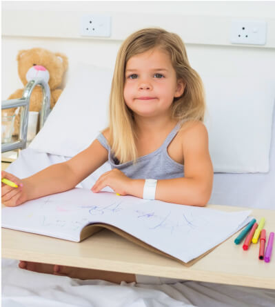 girl drawing in her hospital bed